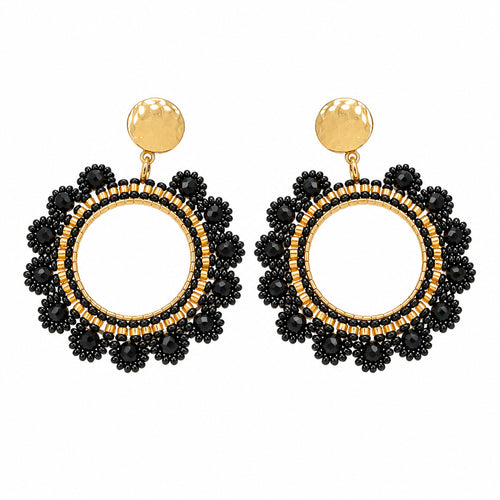 A pair of black beaded hoop earrings with gold-tone metal borders and posts, displayed on a small white card against a white background.