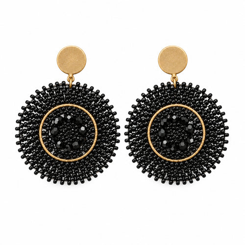 A pair of black beaded drop earrings with gold-toned studs, displayed on a small white card against a white background.