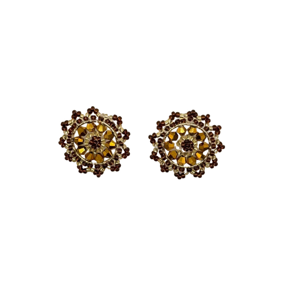 A pair of vintage-style circular earrings with intricate floral detailing in gold and dark brown, set against a plain white background.