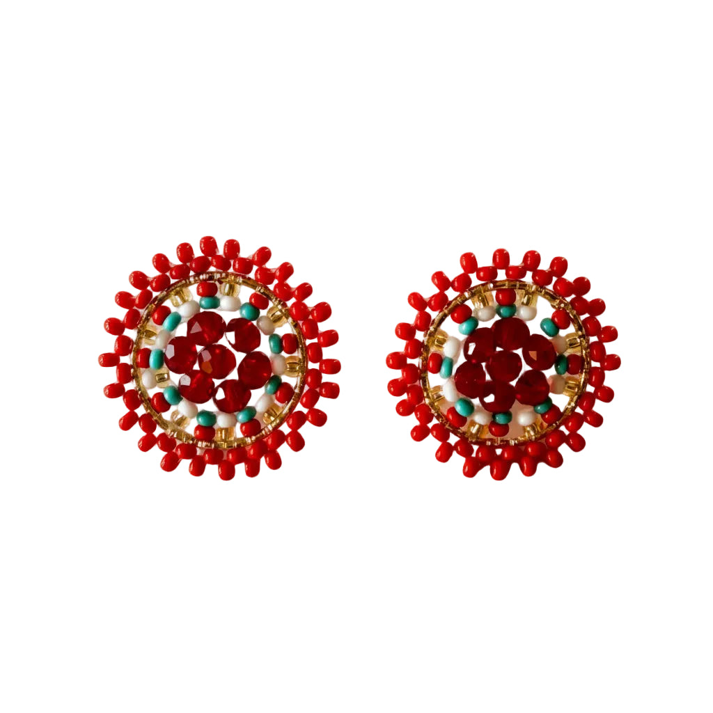 A pair of handmade circular beaded earrings with a red floral center, surrounded by red beads, gold spacer beads, and small turquoise blue beads, displayed on a plain white surface.