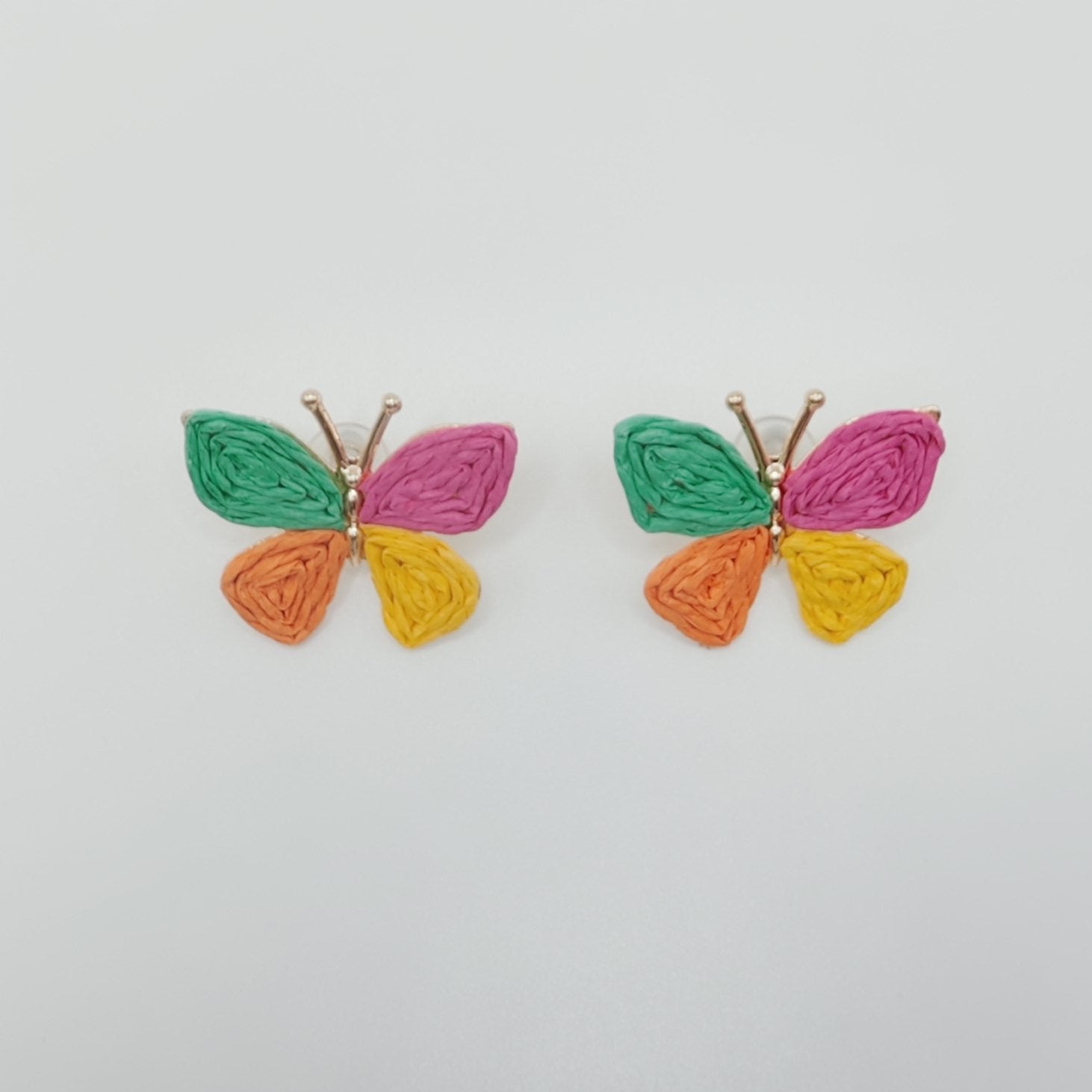 Colorful butterfly-shaped earrings on a light gray background