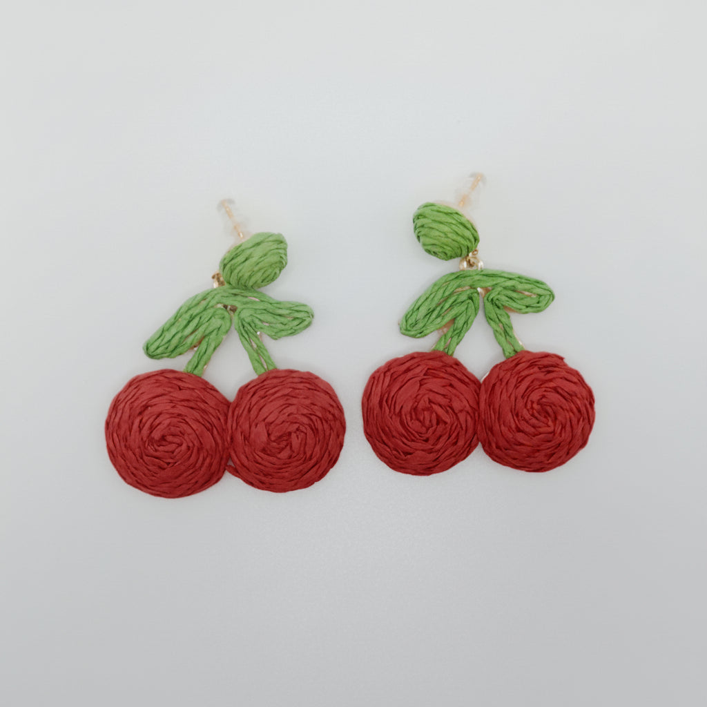 Cherry-themed earrings on a white background