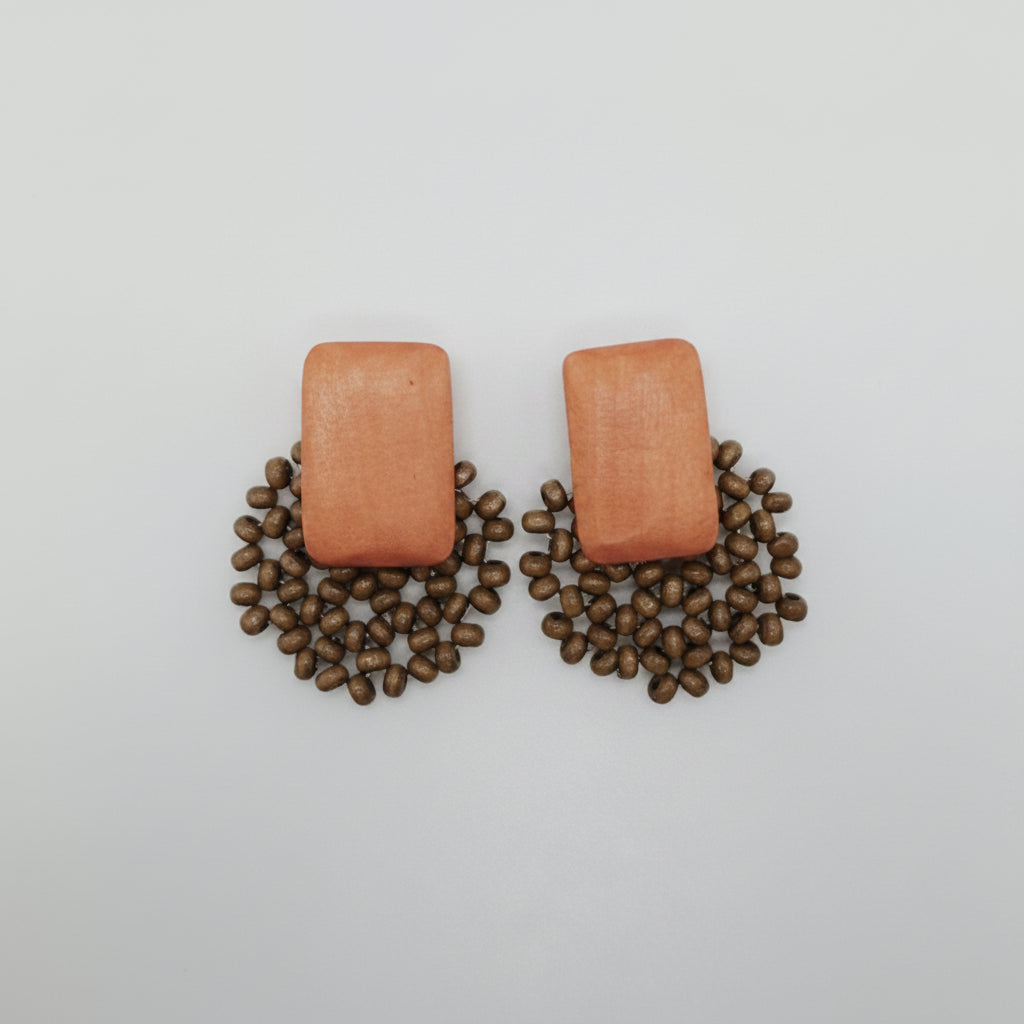 Pair of earrings on a white cushion with a light gray background