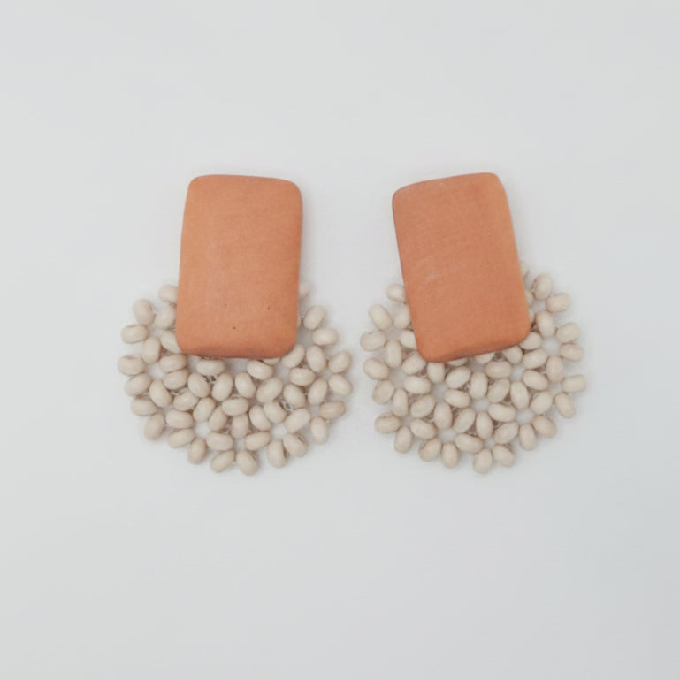 Pair of earrings on a white card with a light gray background