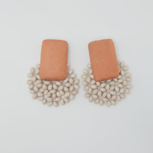 Pair of earrings on a white card with a light gray background