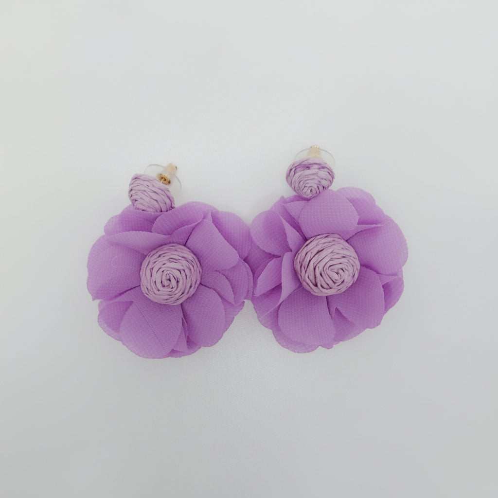 Pair of purple flower-shaped earrings on a light gray background