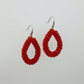 Red teardrop-shaped earrings on a white card with 'KIRKLAND' branding.