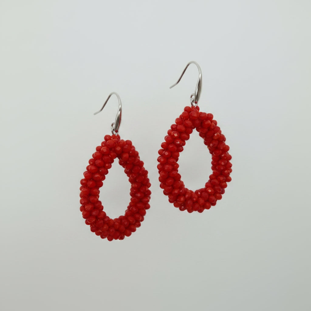 Red teardrop-shaped earrings on a white card with 'KIRKLAND' branding.