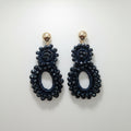 Pair of black beaded earrings on a white background