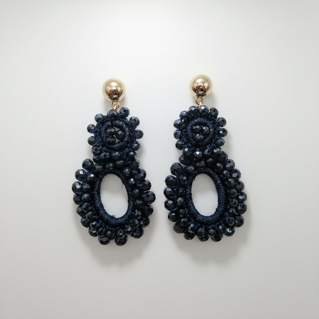 Pair of black beaded earrings on a white background