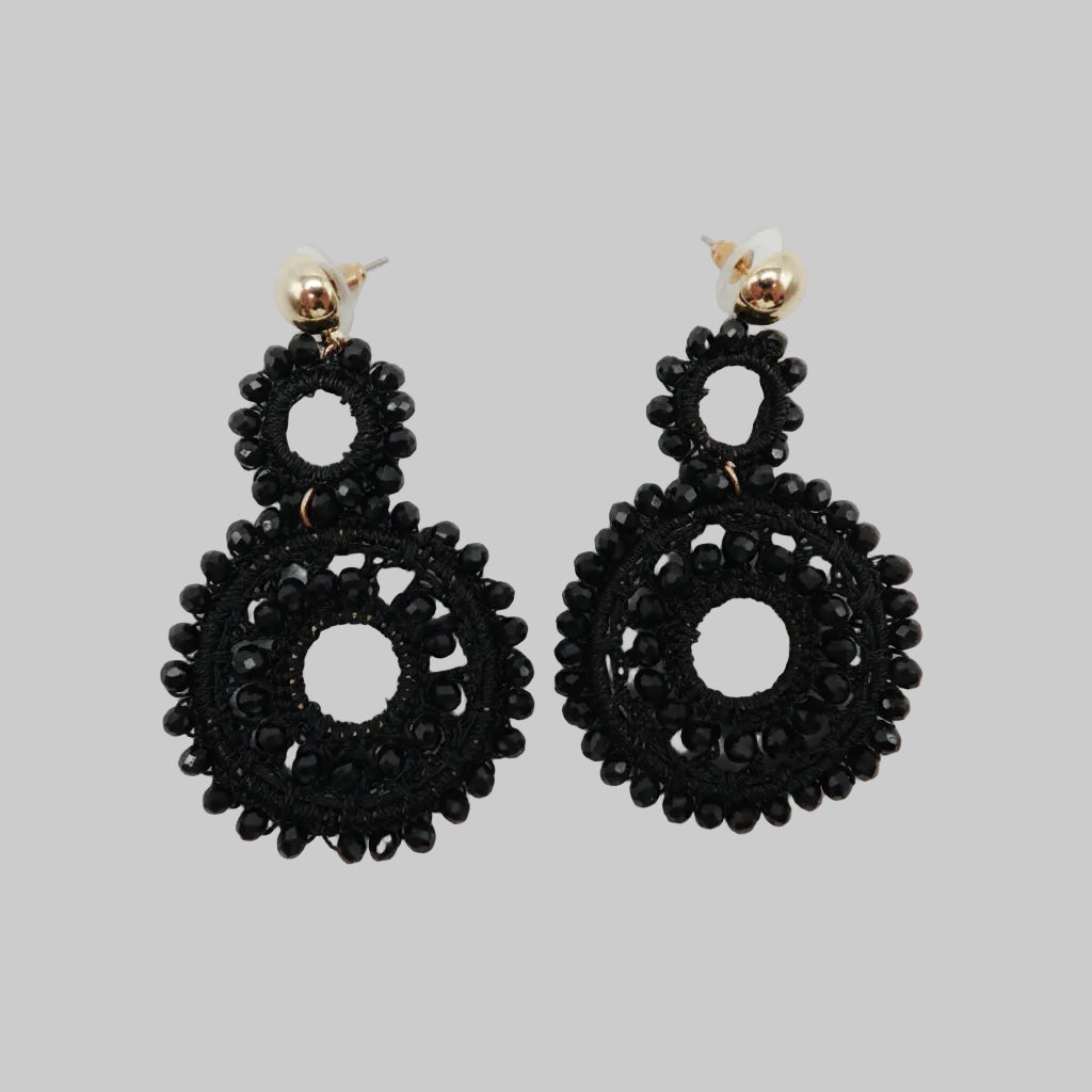 Pair of black earrings on a light gray background