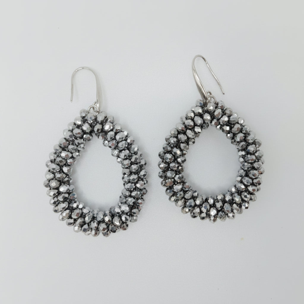 Pair of silver teardrop-shaped earrings on a light gray background