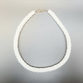Pearl necklace in a silver box with a textured surface