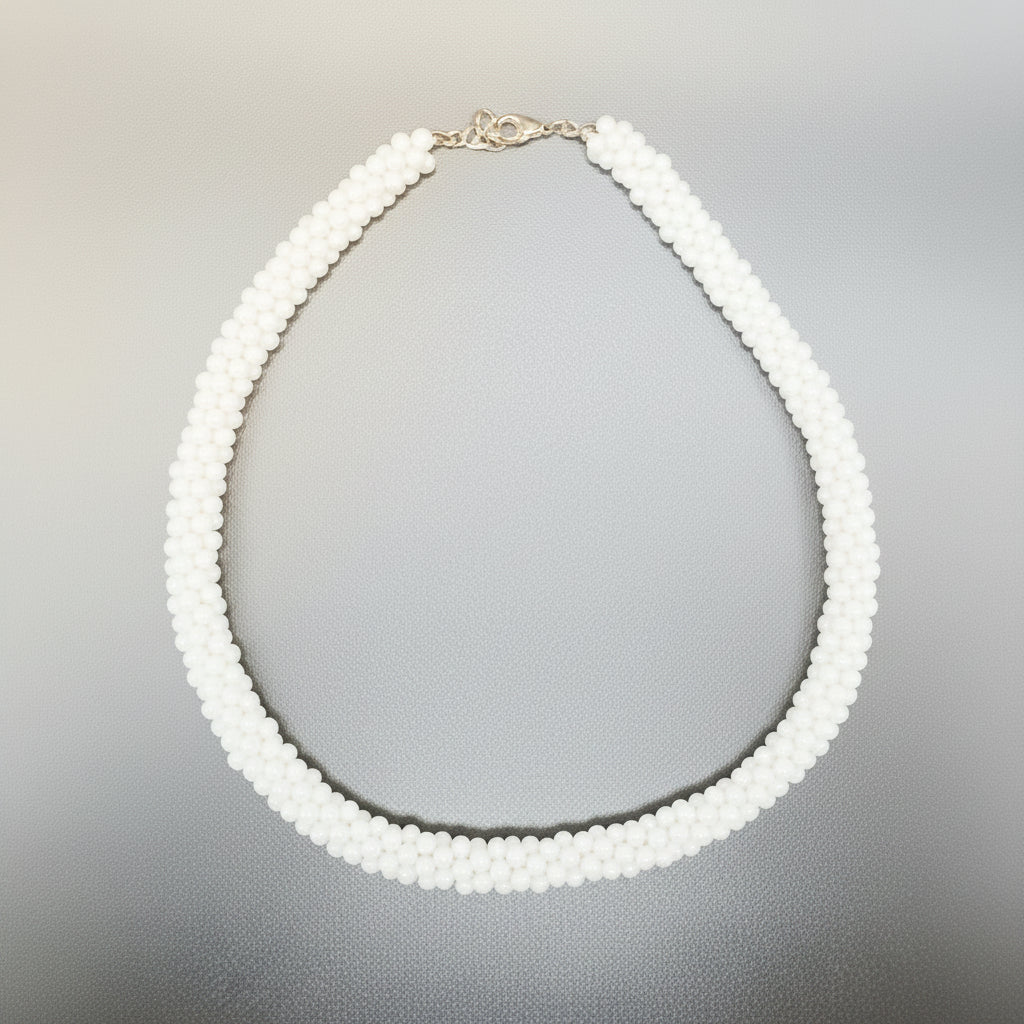 Pearl necklace in a silver box with a textured surface