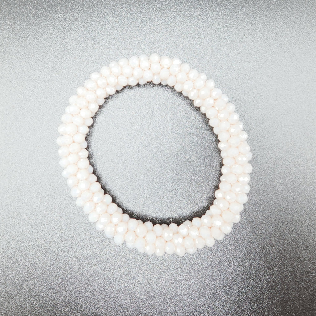 White beaded bracelet on a gray background