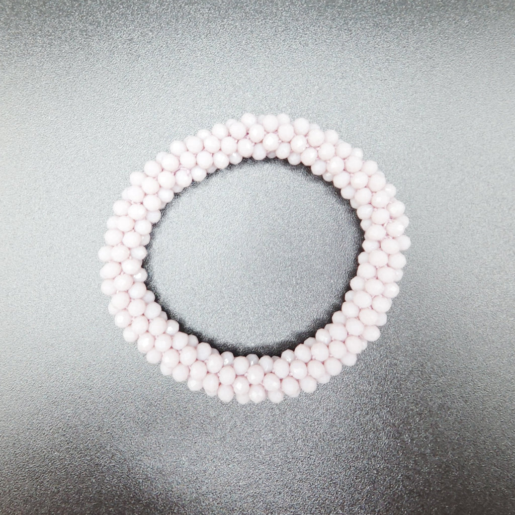 Pearl bracelet on a reflective gray surface