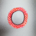 Pink beaded hair tie on a gray background