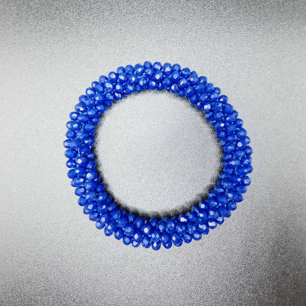 Blue beaded ring on a metallic surface