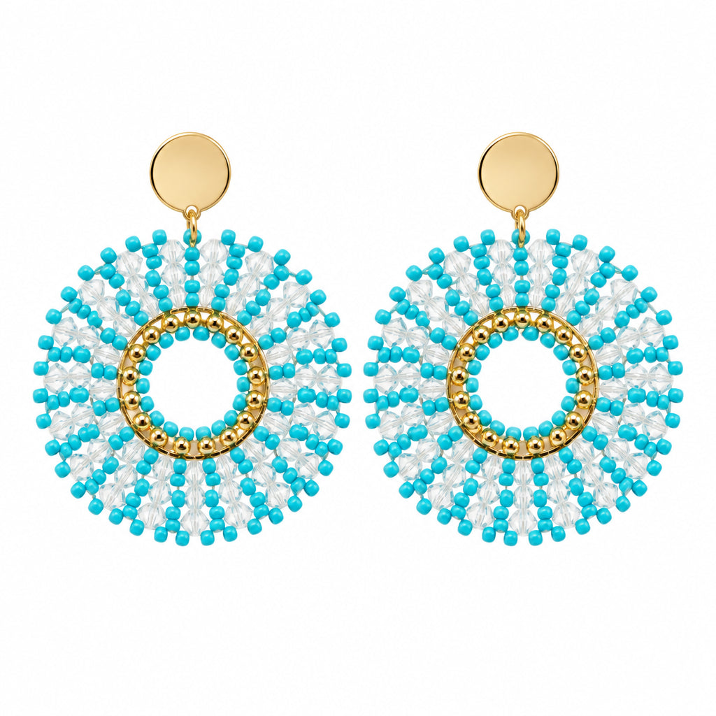 A pair of turquoise and gold beaded dangle earrings displayed on a white card against a white background.