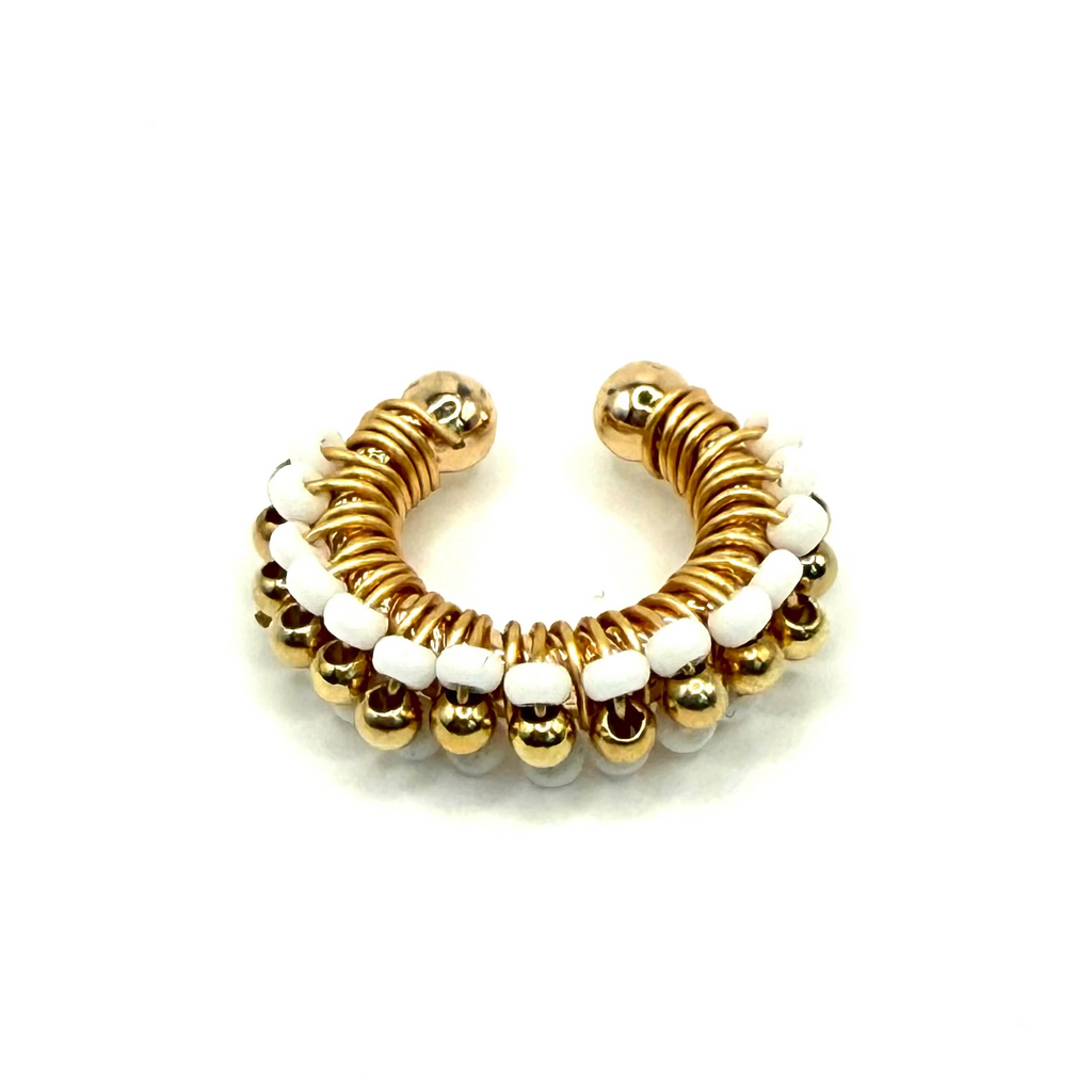 Gold and white beaded hoop earring on a light gray background