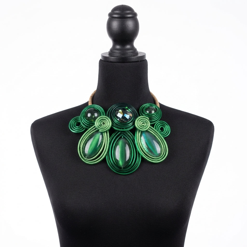 A green soutache statement necklace displayed on a black mannequin bust against a white background.