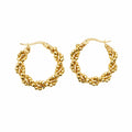 A pair of small gold hoop earrings with a textured, woven-like pattern, displayed on a white surface.