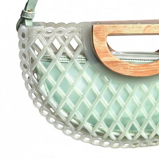 Light green handbag with wooden handle and lattice design on a white background