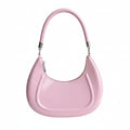 Pink handbag held by a hand against a white background