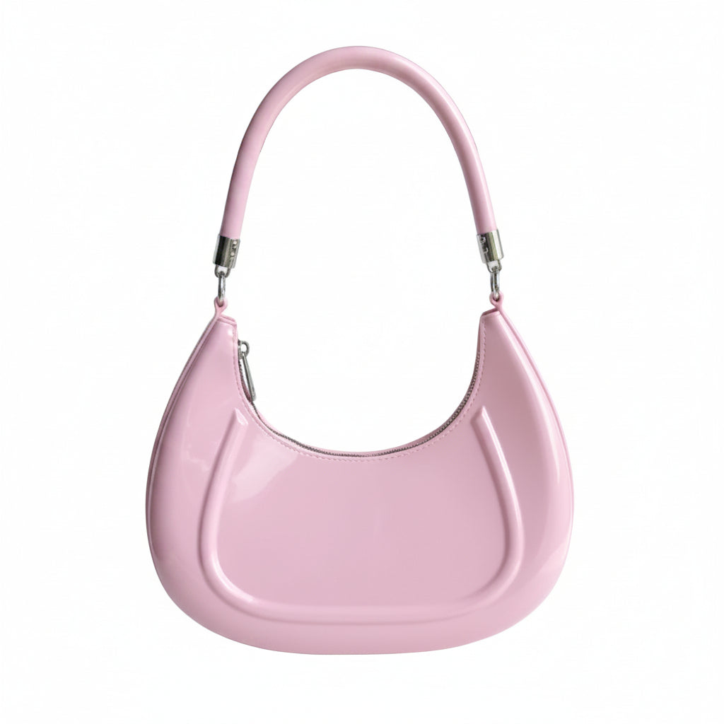 Pink handbag held by a hand against a white background