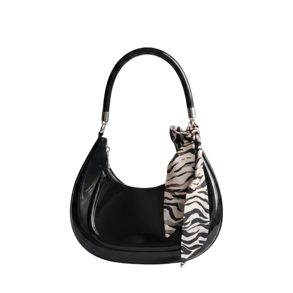 Person holding a zebra-striped bag over a white surface with a neutral-colored wall in the background.