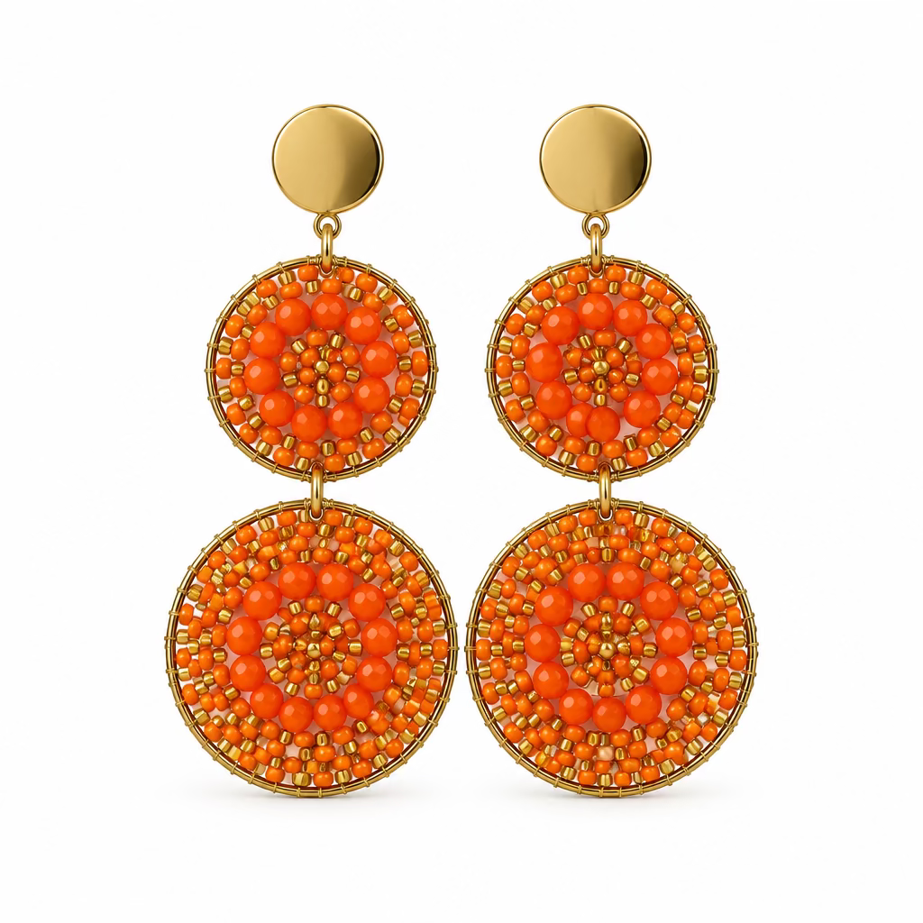 A pair of statement dangle earrings displayed on a white card. Each earring has a round gold-tone top stud and a large circular drop made of concentric rings of bright orange beads with gold-tone metal edging.