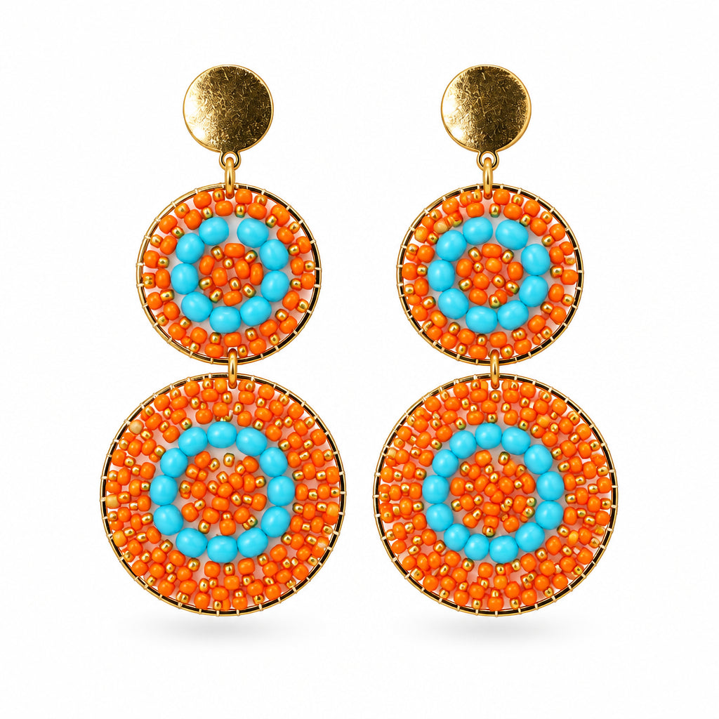 A pair of bohemian-style dangle earrings with circular orange and turquoise mandala patterns and gold-tone studs, displayed on a white background.