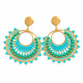A pair of bohemian-style dangle earrings displayed on a white jewelry stand. The earrings feature turquoise and light blue beaded fringe with gold-tone metal hoops and brown stud backs.