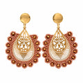 A pair of ornate gold-toned dangle earrings with intricate filigree detailing and red beaded scalloped borders, displayed on a white plastic card against a white background.
