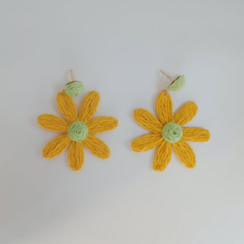 Pair of yellow flower-shaped earrings on a white background