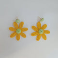 Pair of yellow flower-shaped earrings on a white background