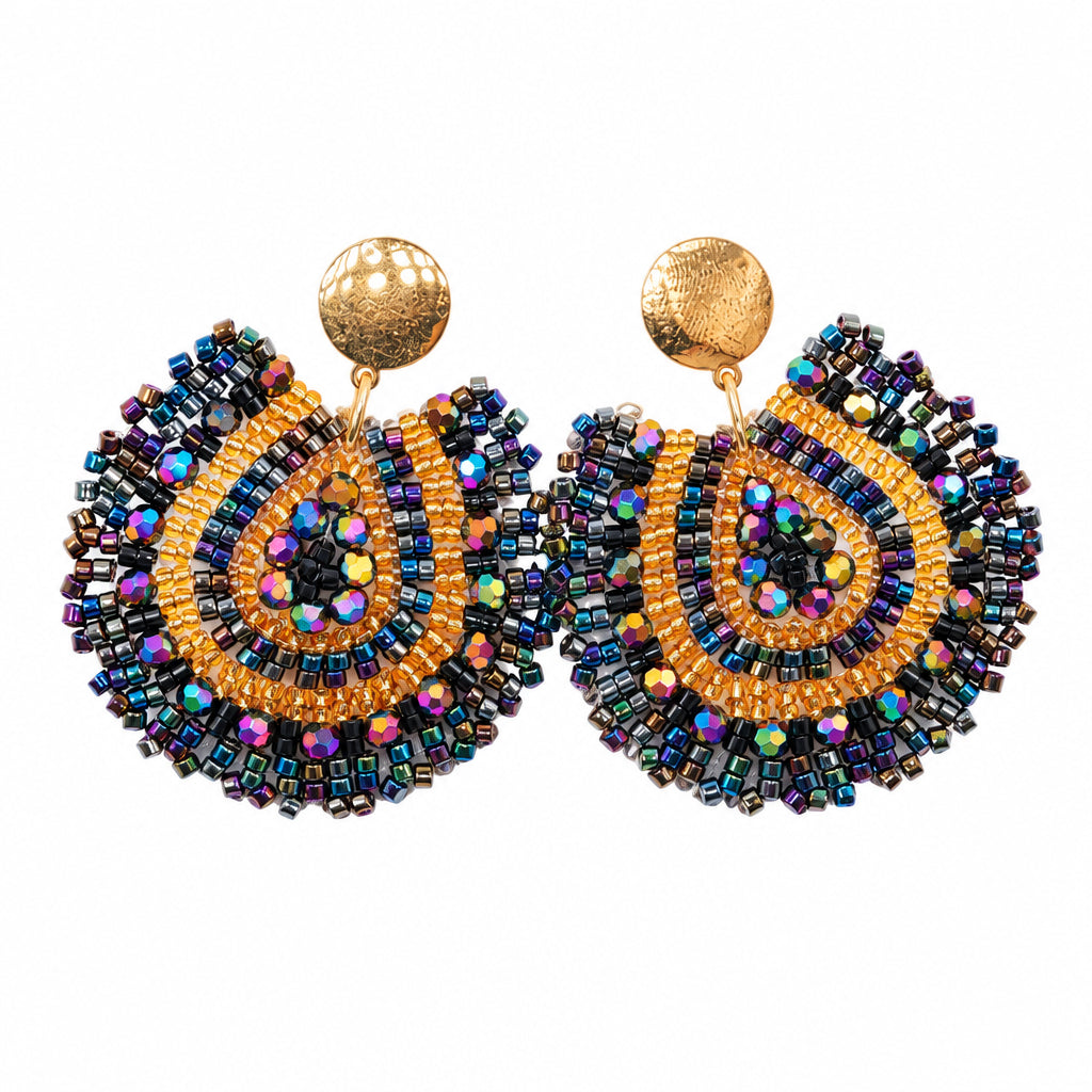A pair of handmade beaded earrings with a gold-tone ball stud and a large, scalloped circular disc of iridescent blue, purple, and gold beads, displayed on a white card against a white background.