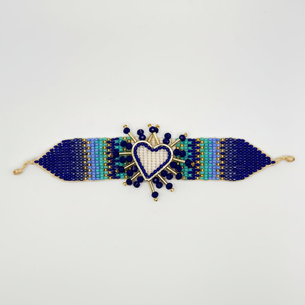 A beaded stretch bracelet with a central heart charm, displayed on a brown cardboard hanger tag against a plain white background.