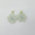 Light green floral earrings on a white background