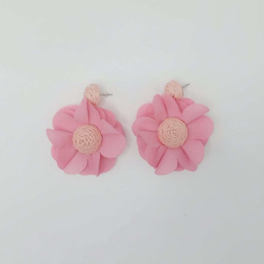 Pink flower-shaped earrings on a white background