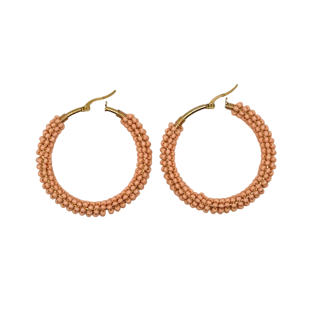 A pair of gold-tone hoop earrings wrapped with multiple strands of small peach-pink beads, displayed on a clean white background.