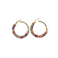 A pair of gold hoop earrings decorated with multiple rows of small multicolored beads, shown on a plain light gray background.