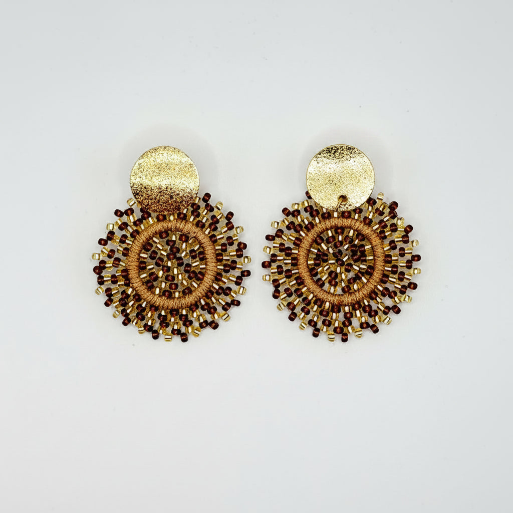 A pair of gold-toned beaded dangle earrings with circular woven details and textured gold backings, displayed on a clean white background.