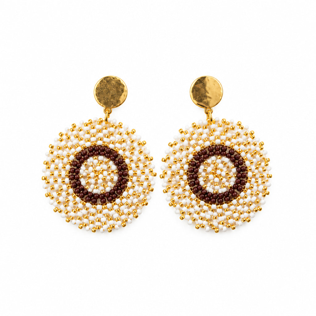 A pair of handmade beaded earrings with gold-toned circular studs and textured gold and brown circular drop charms, displayed on a white card hanger against a white background.