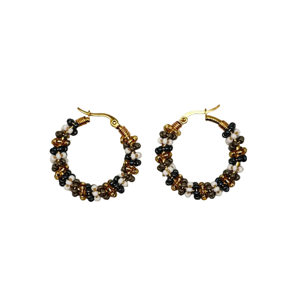 A pair of handmade beaded hoop earrings with gold-tone metal hoops, decorated with rows of small black, white, and amber-brown beads, shown on a plain light gray background.