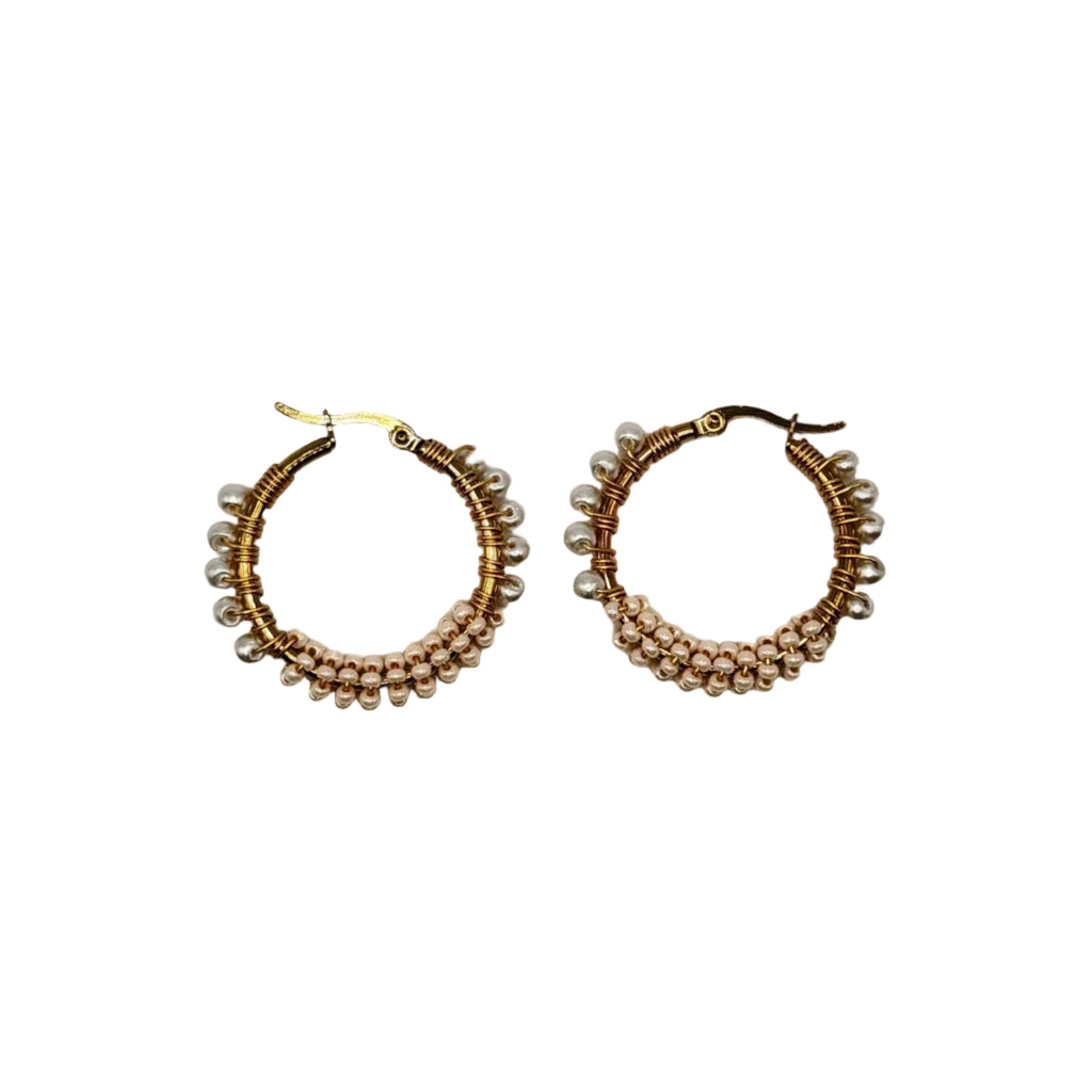 A pair of gold-tone hoop earrings decorated with multiple rows of small metallic beads, displayed on a plain light gray background.