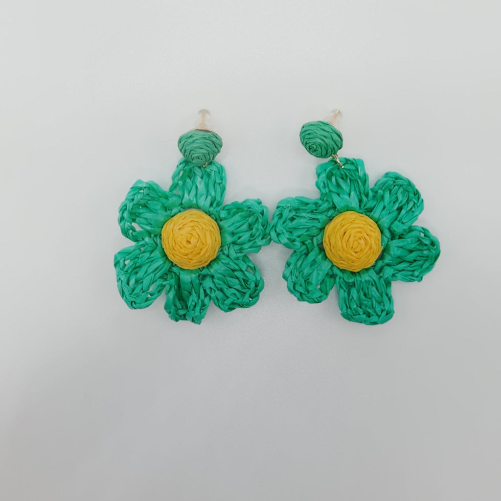 Green flower-shaped earrings with yellow centers on a white background