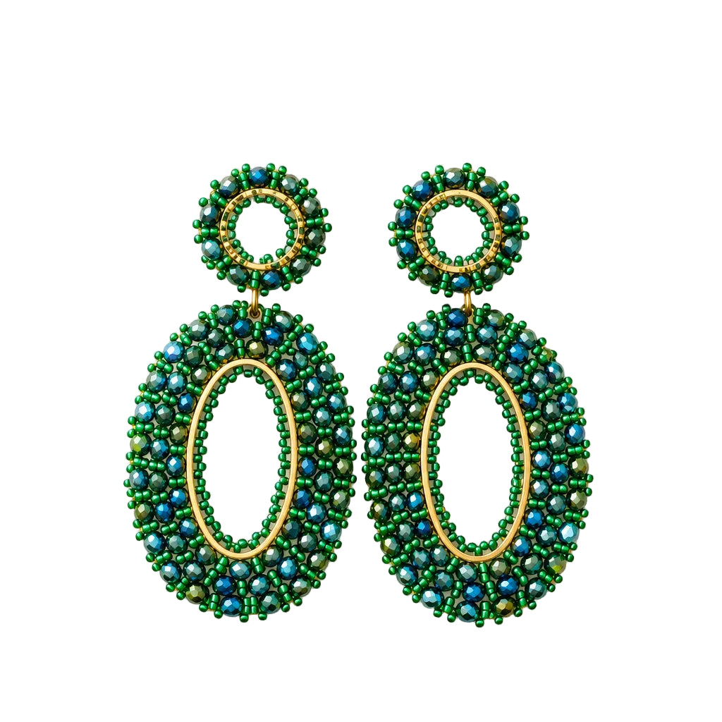 A pair of green beaded drop earrings with oval and circular designs, attached to a small white display card and photographed against a white textured background.