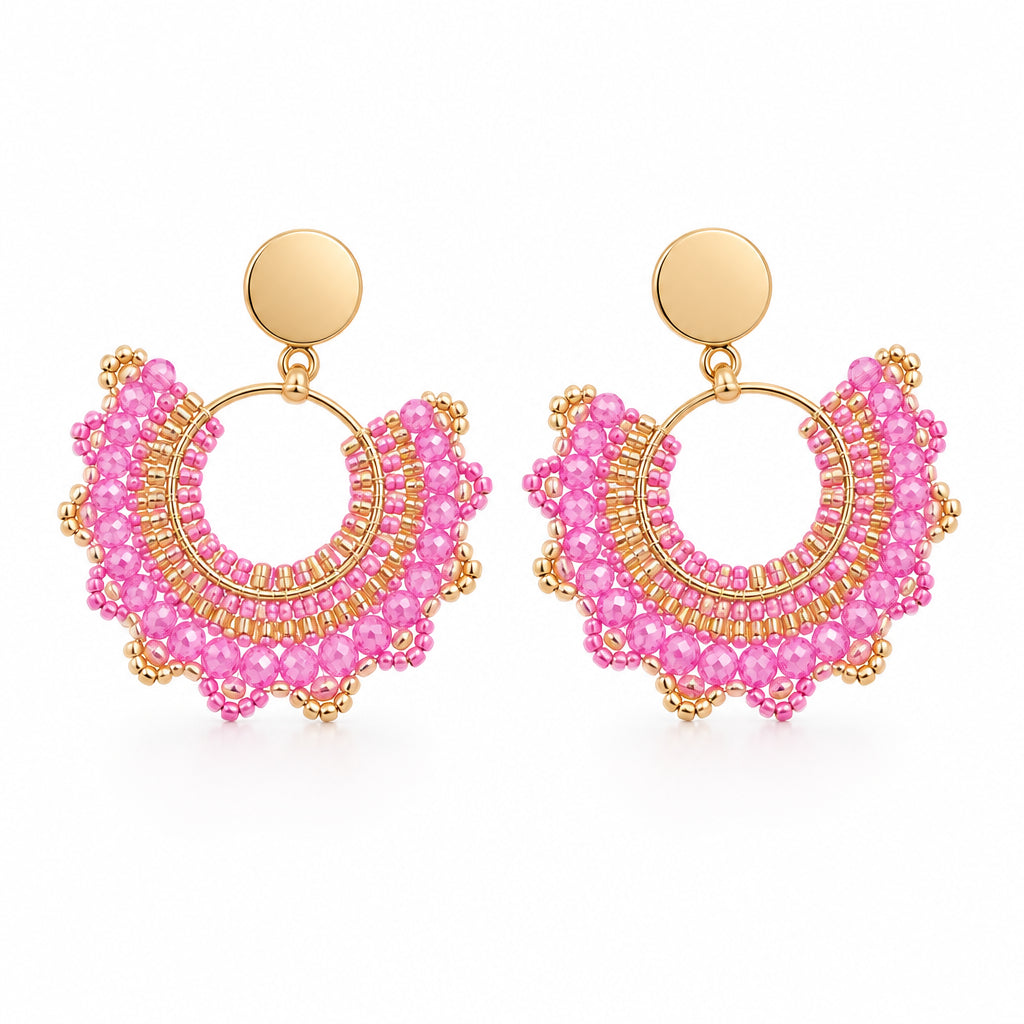 A pair of gold-tone hoop earrings with layered pink beaded fringe, displayed on a white backing card against a light gray background.
