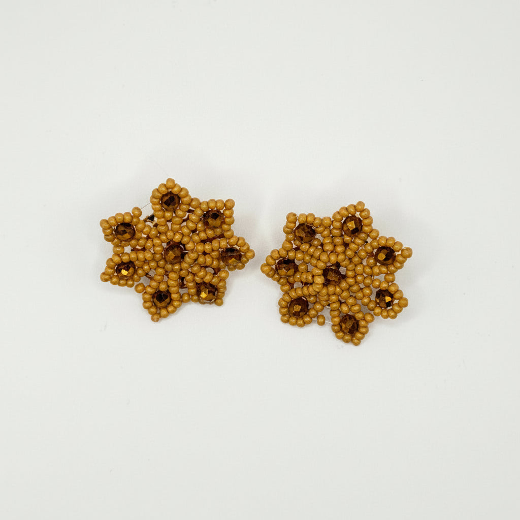A pair of handmade beaded flower-shaped earrings in a warm golden-brown color, featuring small dark brown bead centers, displayed on a clean white background.